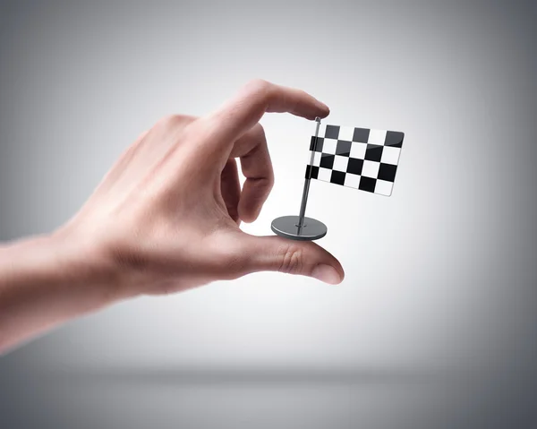 Man's hand holding Checkered Flag — Stock Photo, Image