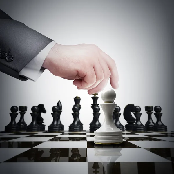 Beyaz satranç satranç tahtası üzerinde yolunu tutan el — Stok fotoğraf