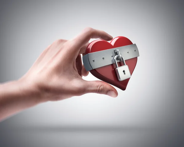 Hand holding heart closed by lock — Stock Photo, Image