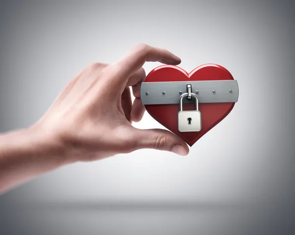 Hand holding heart closed by lock — Stock Photo, Image