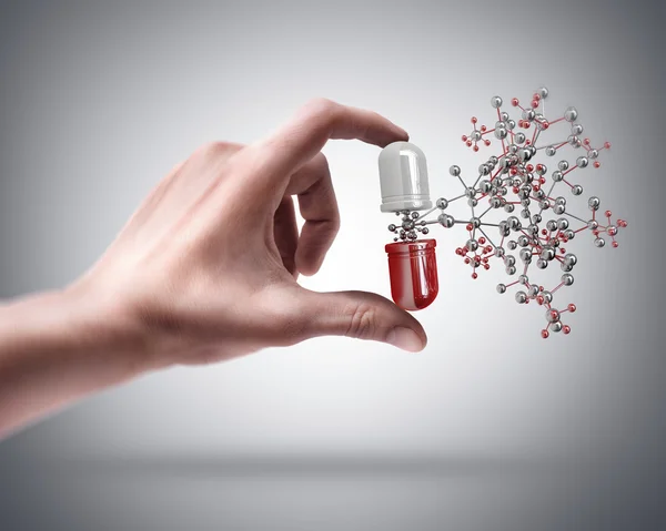 Hand holding pill with molecule — Stock Photo, Image