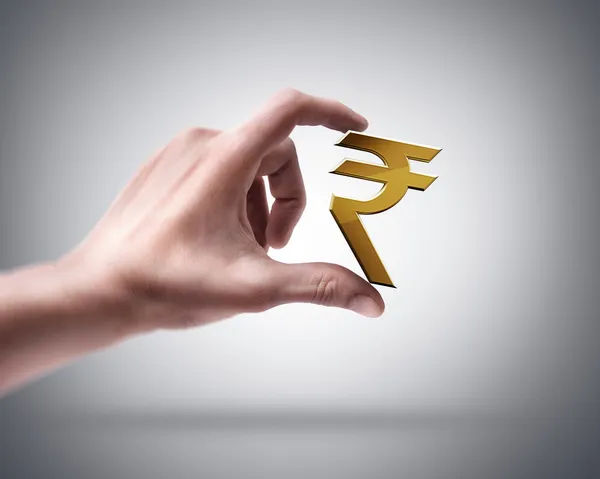 Hand holding gouden Indiase rupee — Stockfoto