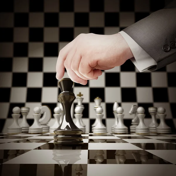 Hand holding witte Schaken figuur op schaakbord — Stockfoto