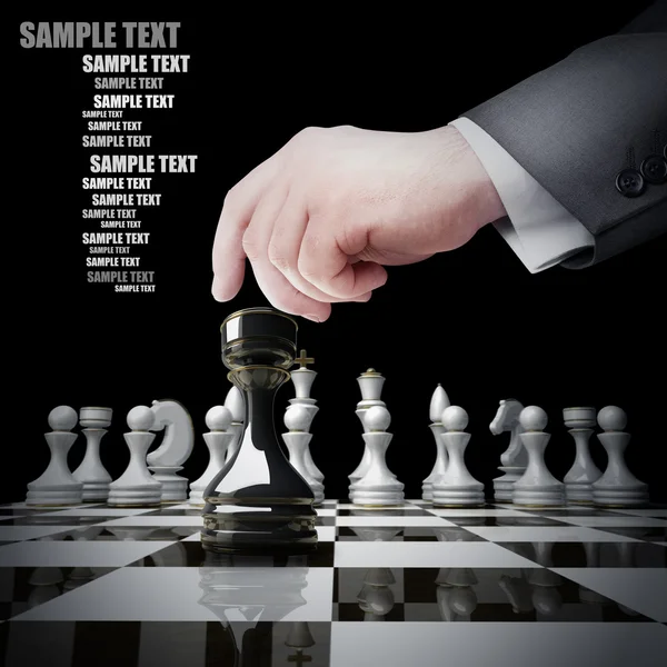 Ręka trzyma szachy biała postać na szachownicy. — Zdjęcie stockowe