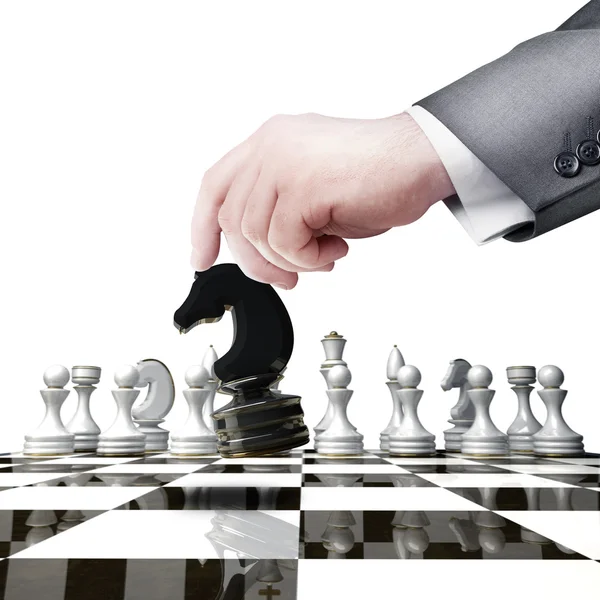 Hand holding black chess figure on chess board — Stock Photo, Image