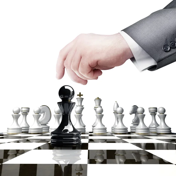 Ruka držící černá šachy figurují na šachovnici — Stock fotografie