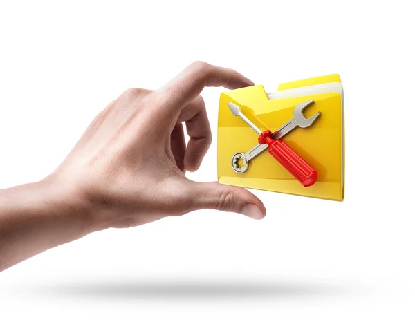 Ręka trzyma folder z symbolem śrubokręt i klucz — Zdjęcie stockowe