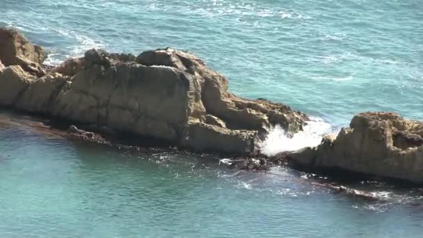 Sea waves splashing through a gap in the rocks. — Stock Video