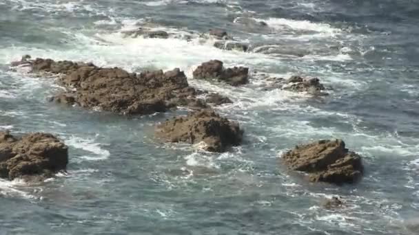 Tengeri hullámok hullanak a sziklák felett.. — Stock videók