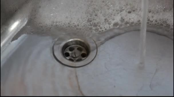 Sprankelende water stroomt beneden het gat van de stekker van een keukengootsteen van de. — Stockvideo