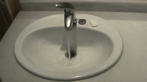 Eau coulant dans un lavabo de salle de bain . — Video