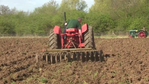 Roter Oldtimer-Traktor zieht Scheibenegge. — Stockvideo