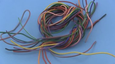 mavi bir arka plan üzerinde dönen rengarenk altı amp elektrik teli.