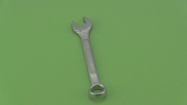 Chrome spanner draaien op een groene achtergrond. — Stockvideo