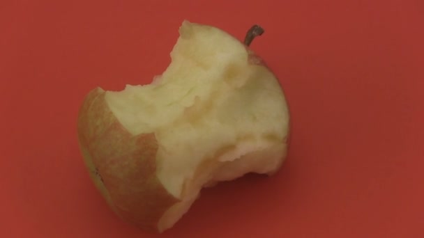 Apple core på en röd bakgrund. — Stockvideo