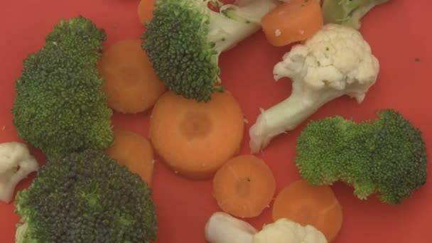 Légumes mélangés sur fond rouge . — Video