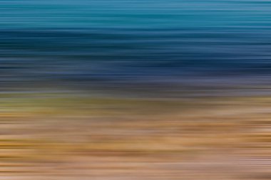 Mavi denizin ve bej taşlı kıyıların güzel, sakin arka planı