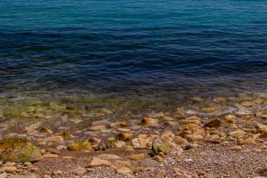 Mavi denizin ve bej taşlı kıyıların güzel, sakin arka planı