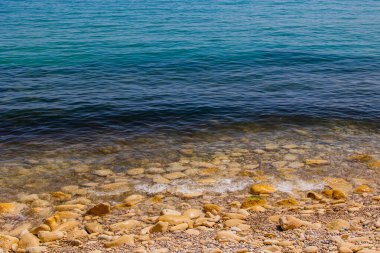 Mavi denizin ve bej taşlı kıyıların güzel, sakin arka planı