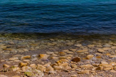 Mavi denizin ve bej taşlı kıyıların güzel, sakin arka planı