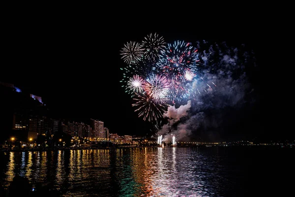 colorful fireworks show at night on the shores of the sea of Alicante Spain