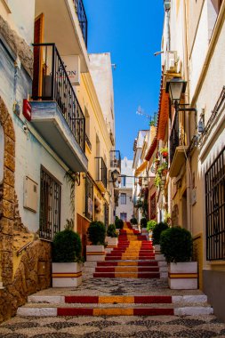 İspanya 'nın Calpe şehrindeki güzel antika merdivenler ülkenin bayrağının rengiyle kırmızı ve sarıya boyanmış.