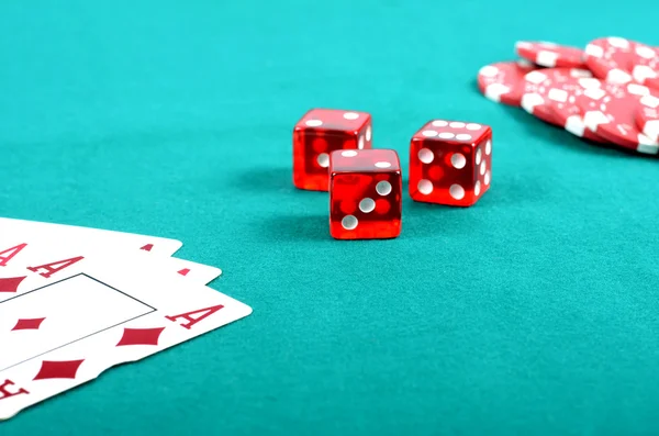 Fichas de poker vermelho, dados e poucos ases em uma mesa de jogo verde — Fotografia de Stock