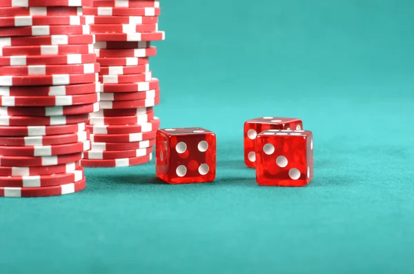 Red poker gambling chips on a green playing table — Stock Photo, Image