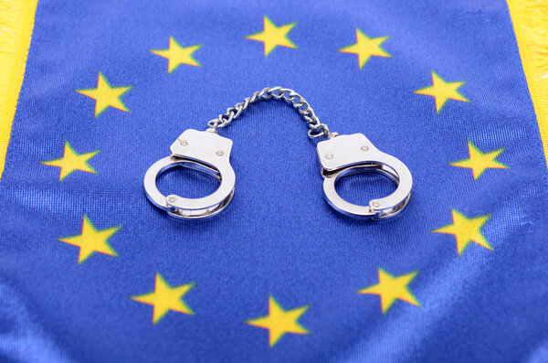 Flag of European Union and handcuffs, European Union law concept