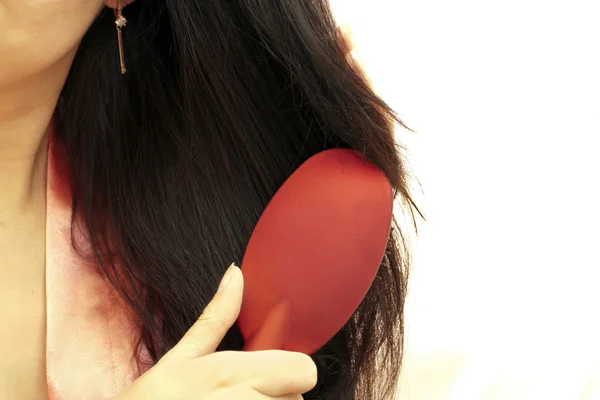 A mulher penteia o cabelo o secador de cabelo — Fotografia de Stock