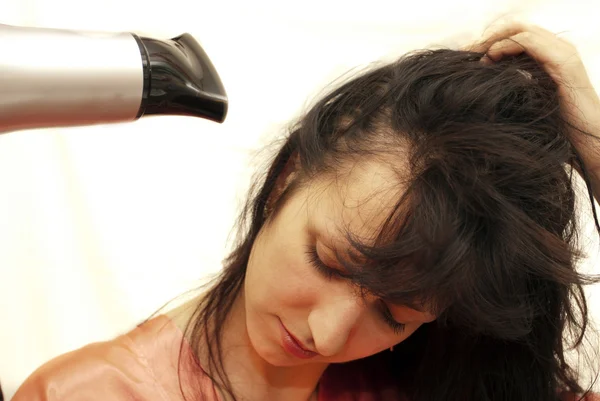 La mujer seca el cabello el secador de pelo —  Fotos de Stock