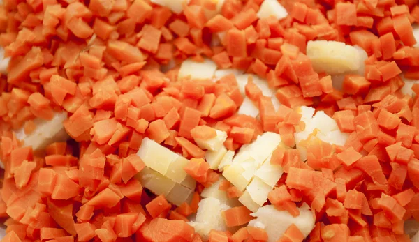 Cutting by cubes carrots and potatoes — Stock Photo, Image