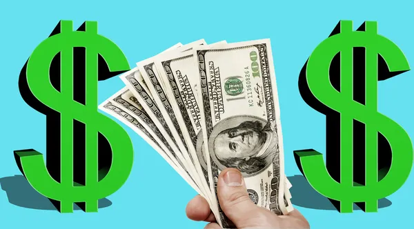 Billetes en dólares estadounidenses en una mano con un signo en dólares de color verde — Foto de Stock