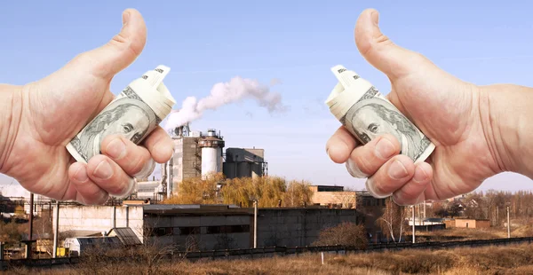 Руки с долларовыми банкнотами против завода — стоковое фото