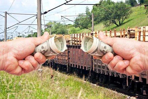 Man's hands with US dollars against the train — Stock Photo, Image