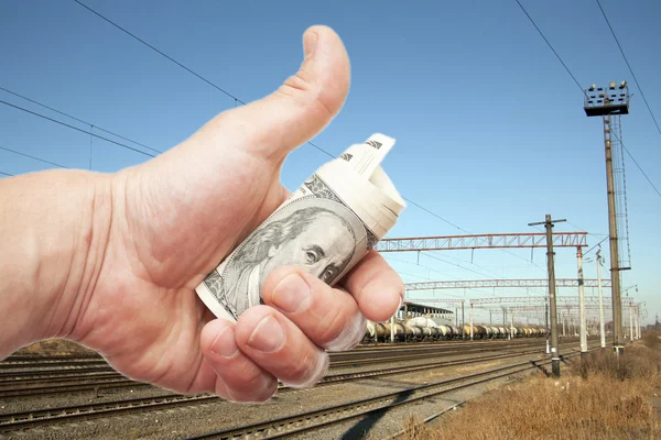 Hand med anteckningar dollar mot järnvägen — Stockfoto