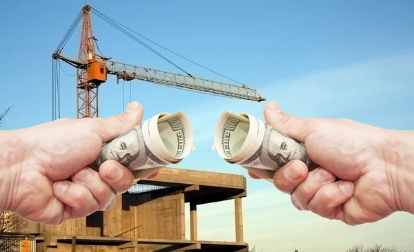 Hundred dollar notes of the USA in a hands against a constructio — Stock Photo, Image