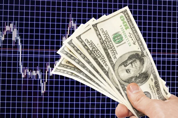 Dollar notes in hand on a blue background with the schedule — Stock Photo, Image