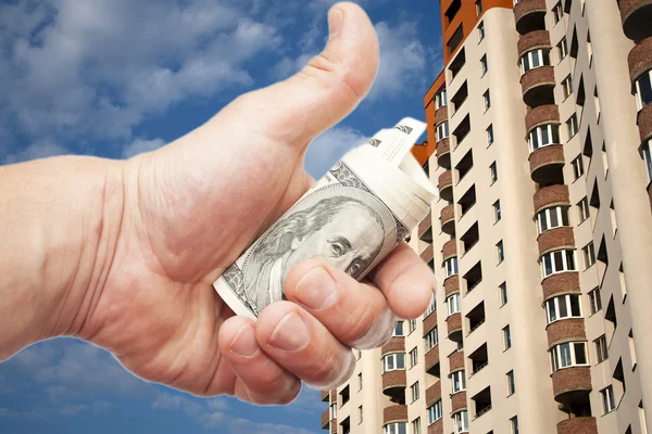 US dollar notes in a hand against  the inhabited high-floor hous — Stock Photo, Image