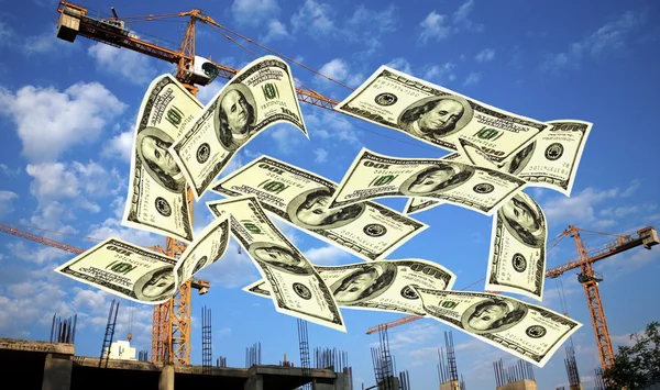 Falling notes of US dollar against cranes Stock Photo