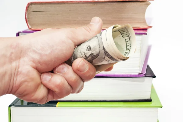 Hand med anteckningar av oss dollar mot böcker — Stockfoto