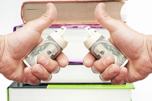 Hand mit Scheinen von uns Dollars gegen Bücher — Stockfoto