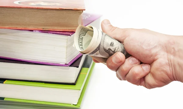 Books and hand with US dollar notes — Stock Photo, Image