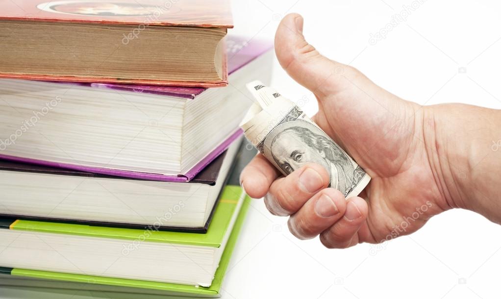 Books and hand with US dollar notes 