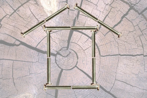 Hütte aus Schrauben gegen Struktur eines Baumes — Stockfoto