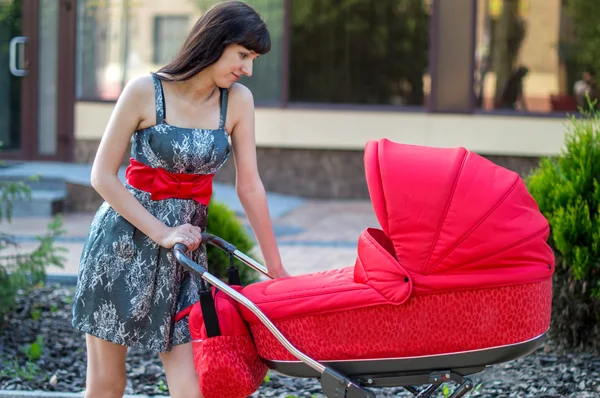 De vrouw met een kinder vervoer op wandeling — Stockfoto