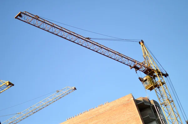 Construction du nouveau bâtiment en brique au moyen de la grue élévatrice — Photo