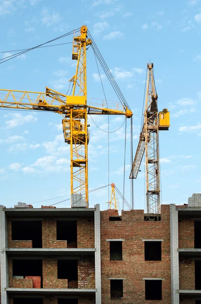 Bouw van de nieuwe bakstenen gebouw door middel van de verheffende kraan — Stockfoto