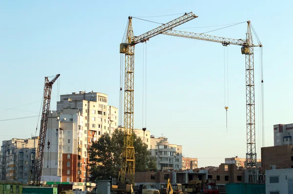 Construcción del nuevo edificio de ladrillo mediante la grúa elevadora — Foto de Stock