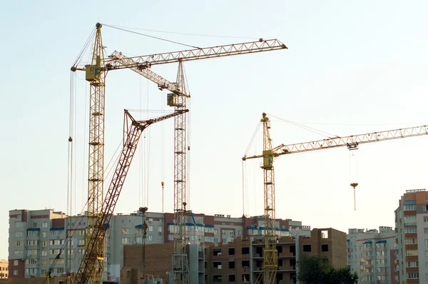 Construcción del nuevo edificio de ladrillo mediante la grúa elevadora — Foto de Stock